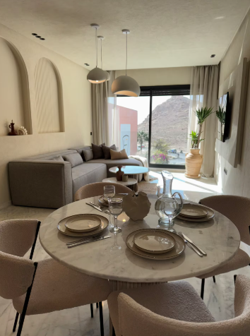 Salon lumineux ouvert sur le balcon, table ronde en marbre